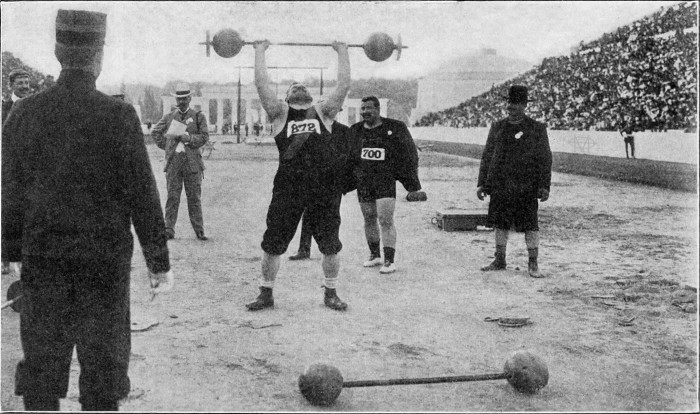 Αθήνα, 9-19 Απρίλιου 1906, Αγώνες Μεσολυμπιάδος, αγώνισμα Άρσης Βαρών με δύο χέρια, στην προσπάθεια ο αυστριακός Γιόζεφ Στάινμπαχ (Νo 872 - δεύτερος νικητής) που παρακολουθείται από τον Δημήτρη Τόφαλο (Νo 700 - πρώτο νικητή).