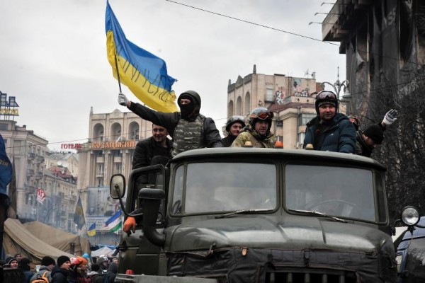 Αντικυβερνητικοί διαδηλωτές,  κρατούν την ουκρανική σημαία, πάνω σε στρατιωτικό όχημα που κινείται από την πλατεία Ανεξαρτησίας στο κέντρο του Κιέβου ( Photo/Louisa Gouliamaki)