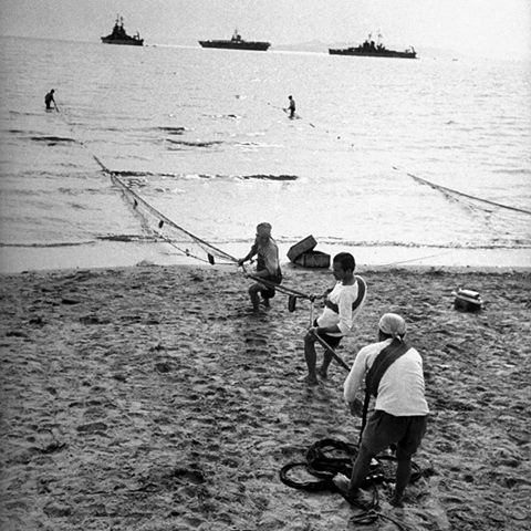 Mark Kauffman, Νοέμβριος 1948, Πειραιάς, ψαράδες στο Φάληρο καλάρουν για μαρίδα με φόντο τα συμμαχικά πλοία. (Συλλογή Θεόδωρος Μεταλληνός)