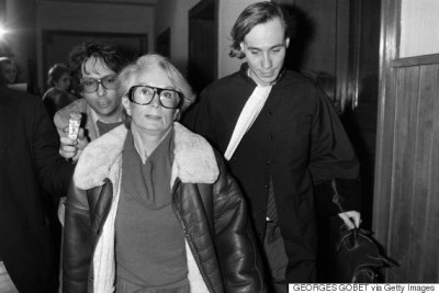 (FILES) A file picture taken on January 20, 1986 shows Fernande Grudet also known as Madame Claude (L) walking with her lawyer Bruno Simonetta at the Court of Cahors during her trial. Mme Claude died on December 19, 2015 at the Sources hospital in Nice. She ran in the 1960s a major international prostitution network supplying the services of hundreds of elite call-girls to businessmen and politicians. / AFP / Georges GOBET (Photo credit should read GEORGES GOBET/AFP/Getty Images)