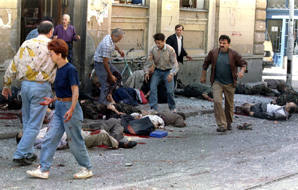 Sarajevans carry the dead and wounded outside of the cities indoor market after a mortar shell exploded near the entrance to the building August 28. At least 33 people were killed and 88 wounded when a shell hit a crowded street in the Bosnian capital Sarajevo on Monday morning in the worst attack on the city for more than a year