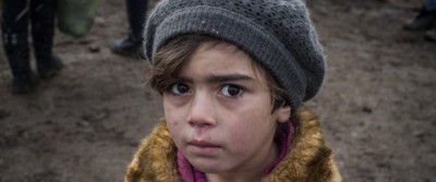 TOPSHOT - A child waits with other migrants and refugees for security check after crossing the Macedonian border into Serbia, near the village of Miratovac, on January 29, 2016. More than one million migrants and refugees crossed the Mediterranean Sea to Europe in 2015, nearly half of them Syrians, according to the UN refugee agency, UNHCR. The International Organisation for Migration said las week that 31,000 had arrived in Greece already this year. / AFP / ARMEND NIMANI (Photo credit should read ARMEND NIMANI/AFP/Getty Images)