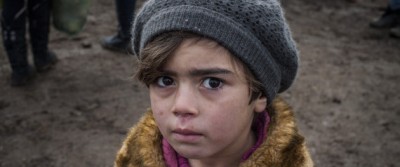 TOPSHOT - A child waits with other migrants and refugees for security check after crossing the Macedonian border into Serbia, near the village of Miratovac, on January 29, 2016. More than one million migrants and refugees crossed the Mediterranean Sea to Europe in 2015, nearly half of them Syrians, according to the UN refugee agency, UNHCR. The International Organisation for Migration said las week that 31,000 had arrived in Greece already this year. / AFP / ARMEND NIMANI (Photo credit should read ARMEND NIMANI/AFP/Getty Images)