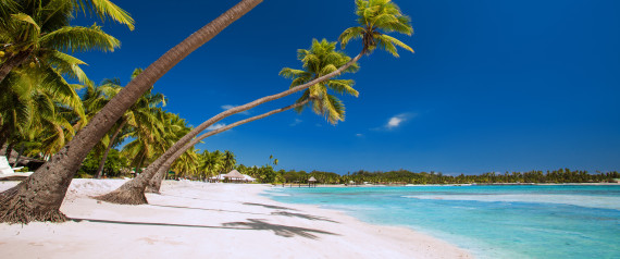 Few palm trees over stunning tropical lagoon with white beach