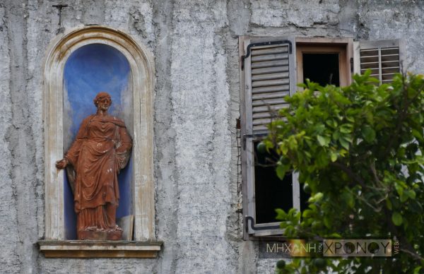 Η πήλινη γυναικεία μορφή είναι ενσωματωμένη στον τοίχο και για να αφαιρεθεί πρέπει να σπάσει. Μαζί με αυτήν διατηρήθηκε η κόγχη με την κορνίζα και το αρχικό γαλάζιο χρώμα