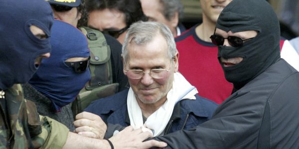 Italian police officers lead Sicilian Mafia boss Bernardo Provenzano from a police station in the southern city of Palermo