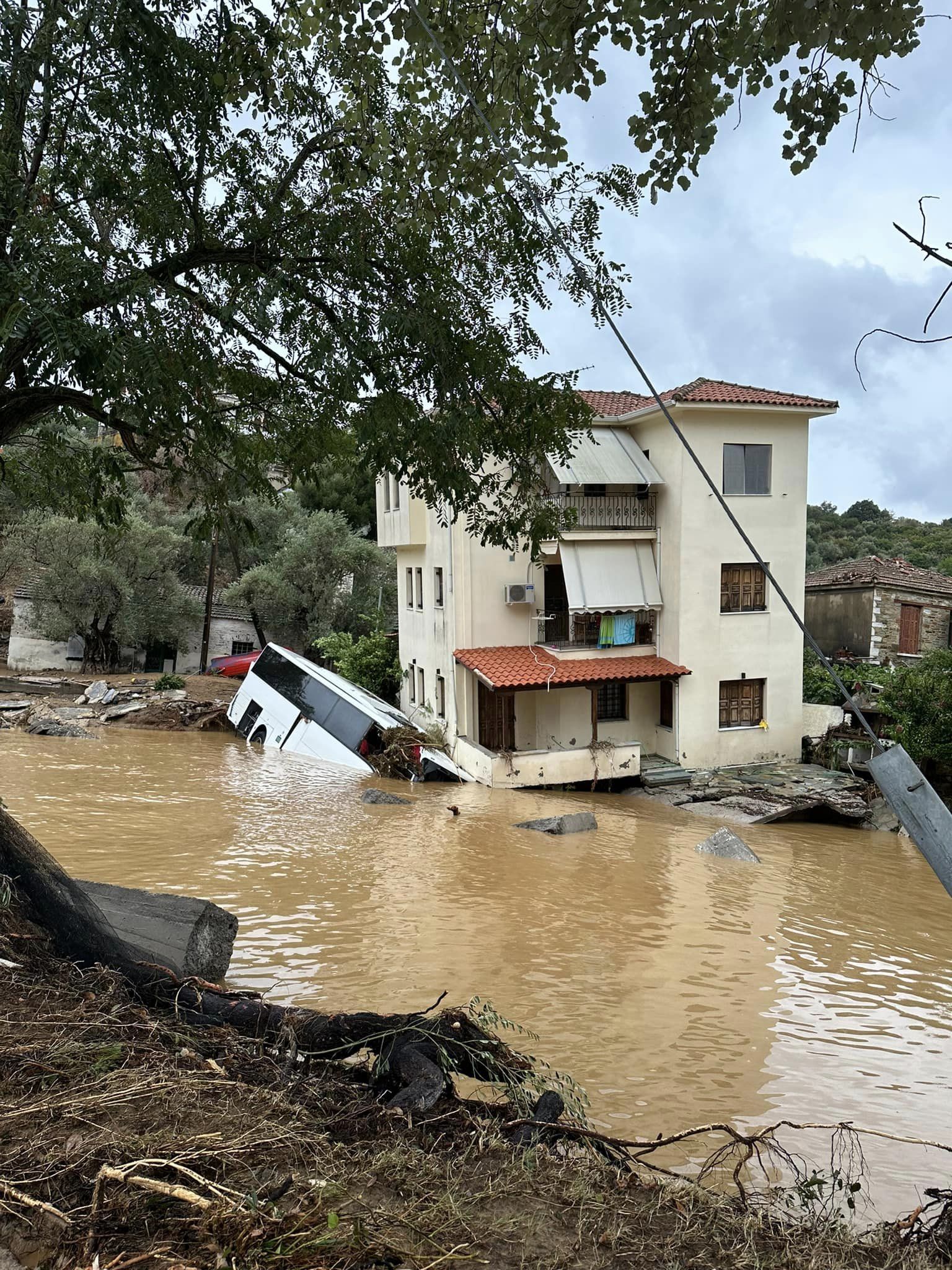 Εικόνες αποκάλυψης στο Πήλιο.  Τριώροφη κατοικία πήρε κλίση και  «στηρίζεται» σε τουριστικό λεωφορείο που παρασύρθηκε